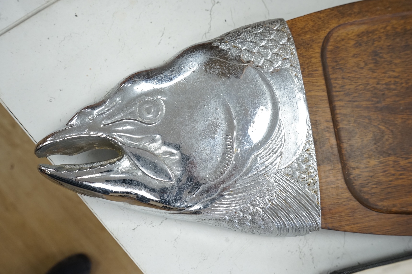 A wooden 'Fish' serving platter with plated mounts and a pair of servers, platter 87cm long